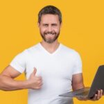 man-programmer-with-laptop-show-thumb-up-isolated-yellow-background-man-programmer_474717-100795